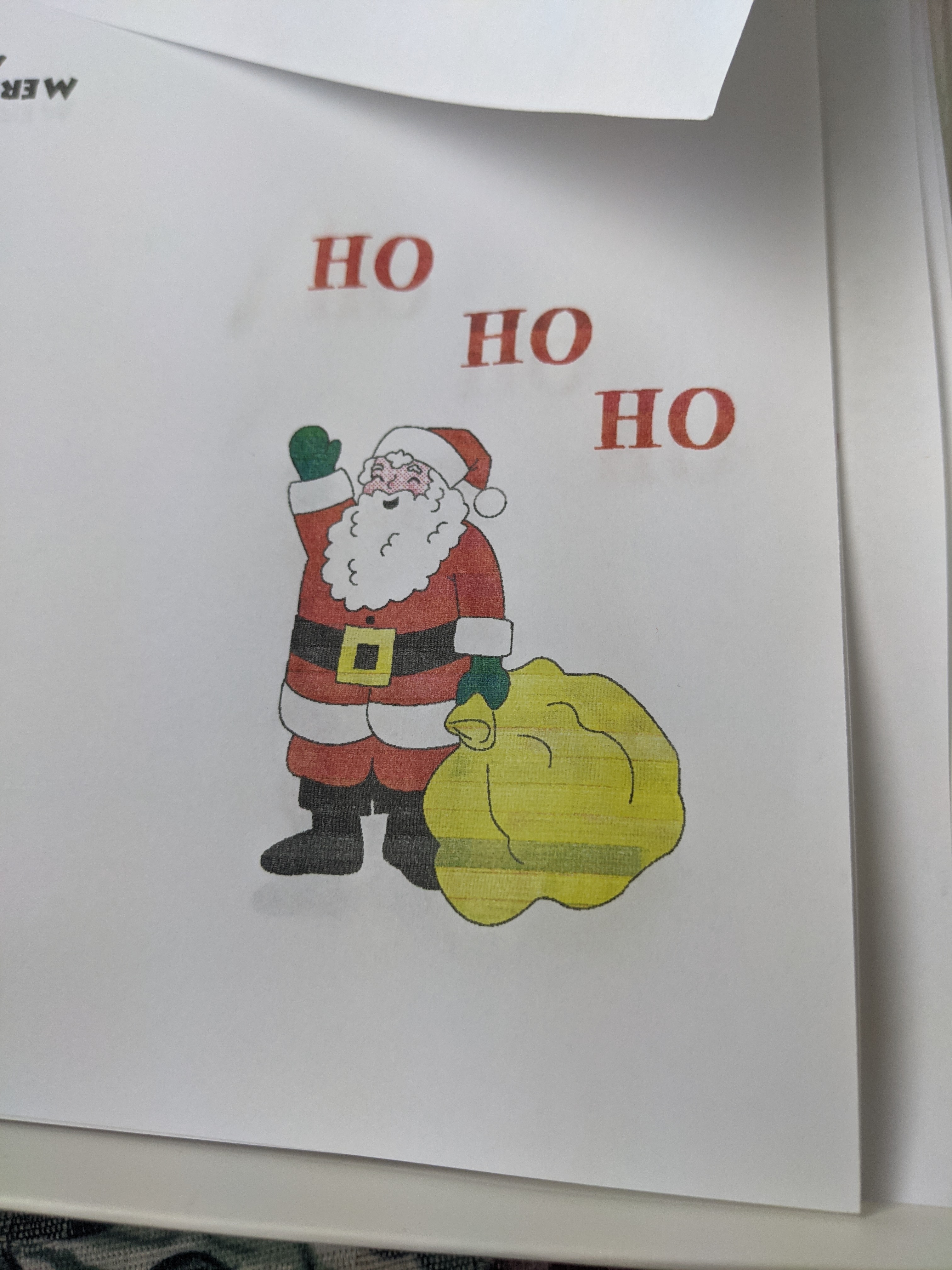 a clipart image of Santa Clause holding a yellow bag that says HO HO HO
bove him it's printed very roughly because it's from a dot matrix printer